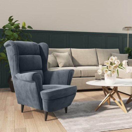 Comfortable, upholstered armchair with metal legs, cozy reading chair, dark grey velvet lounge chair for the living room or bedroom